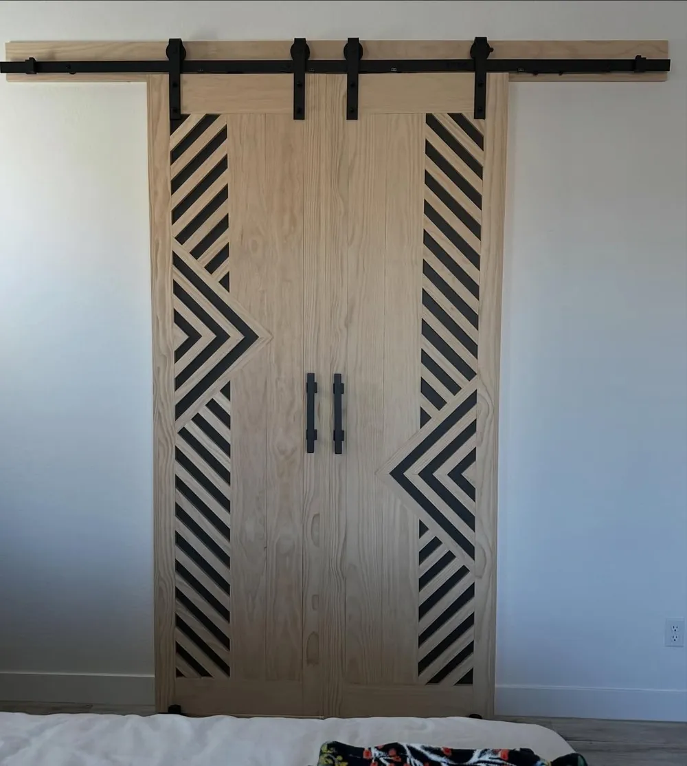 Double barn doors with black chevron pattern, full rail in view