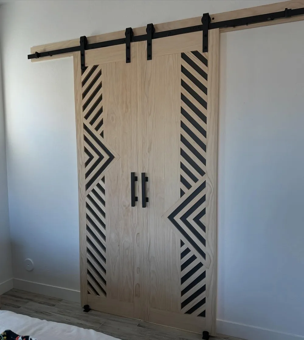 Bypass barn doors with diamond and chevron slat inlay in a bedroom