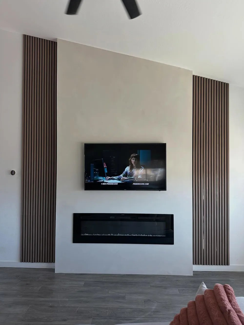 Plaster and walnut slat wall with a linear fireplace.