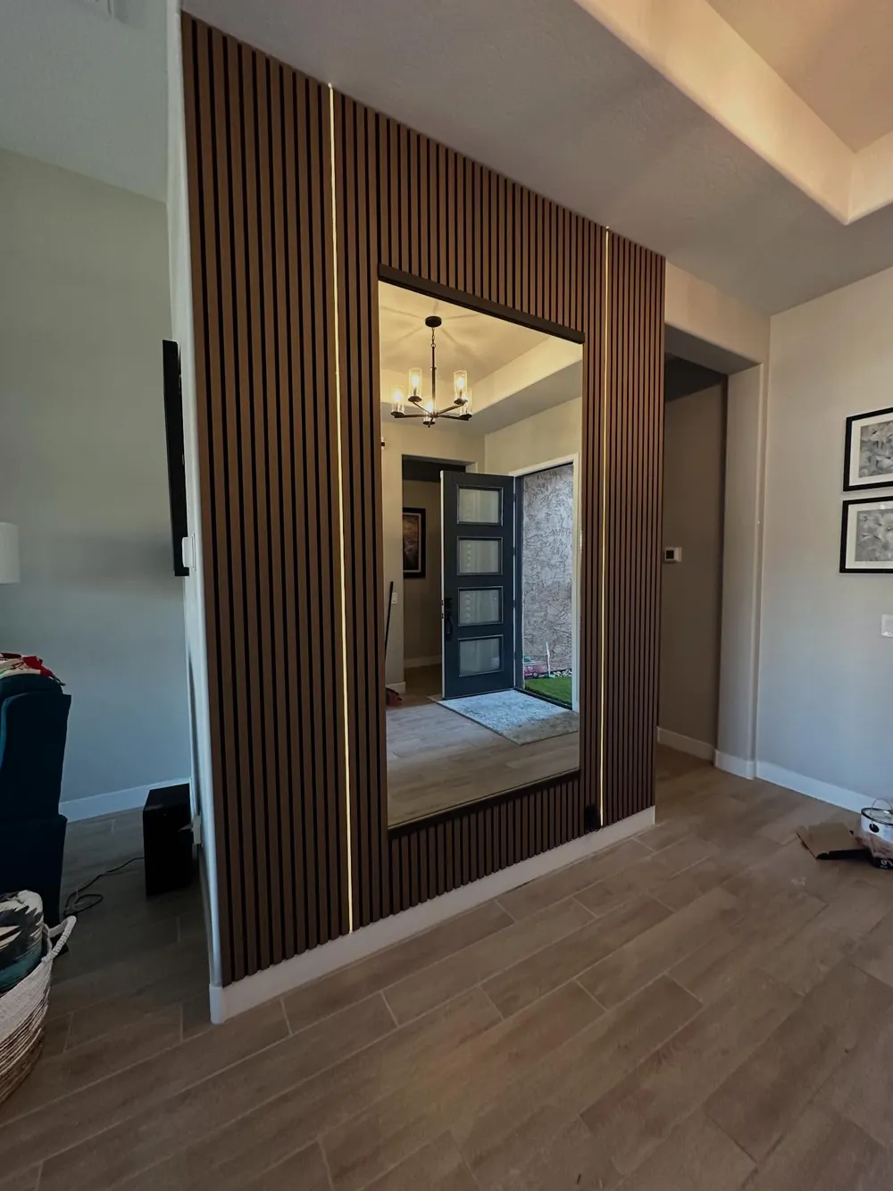 Full length mirror door set within a wood slat entry wall