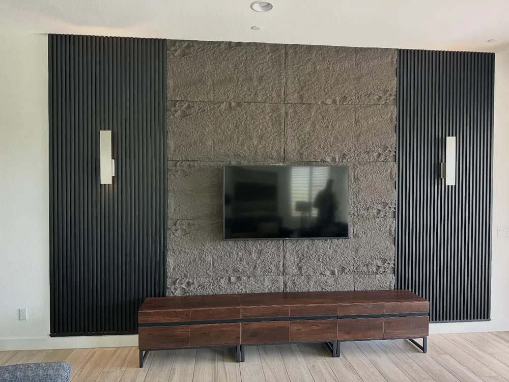Split face stone anchors a fluted wood media wall.