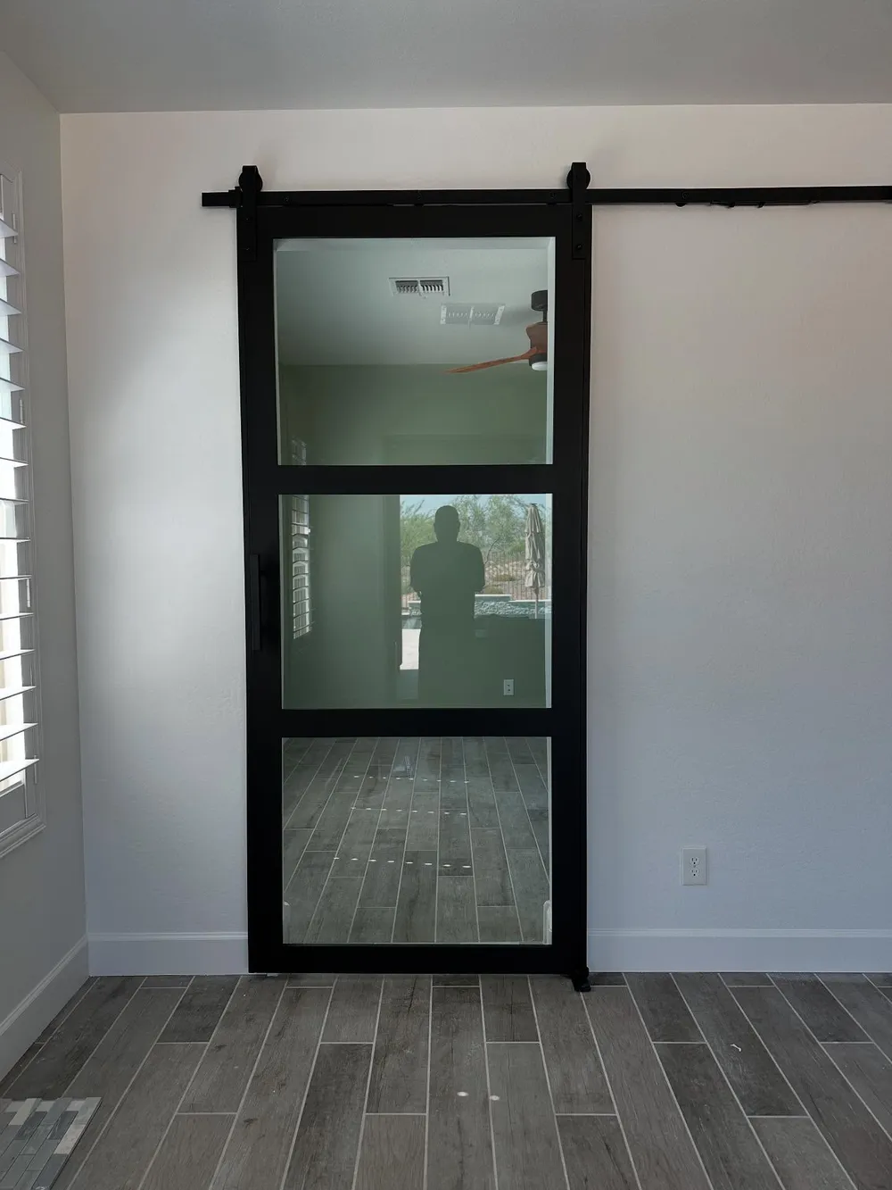 Black framed glass panel barn door on exposed rail