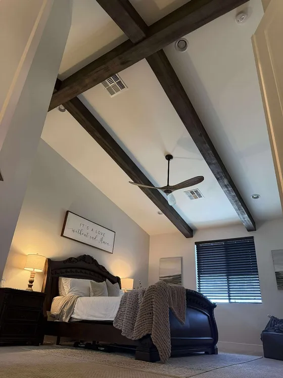 Crossed ceiling beams over a vaulted bedroom