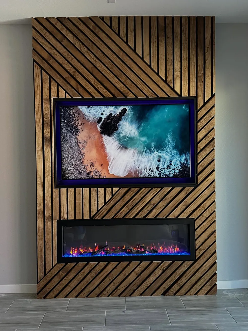 Diagonal slat accent wall with a framed television and fireplace