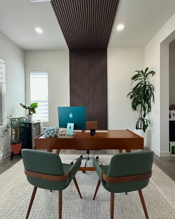 A vertical wood slat accent runs from ceiling to wall behind a walnut desk.